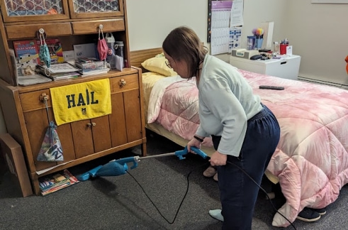a woman vacuuming her bedroom