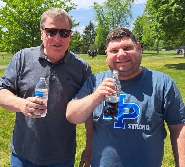two men holding bottles of soda